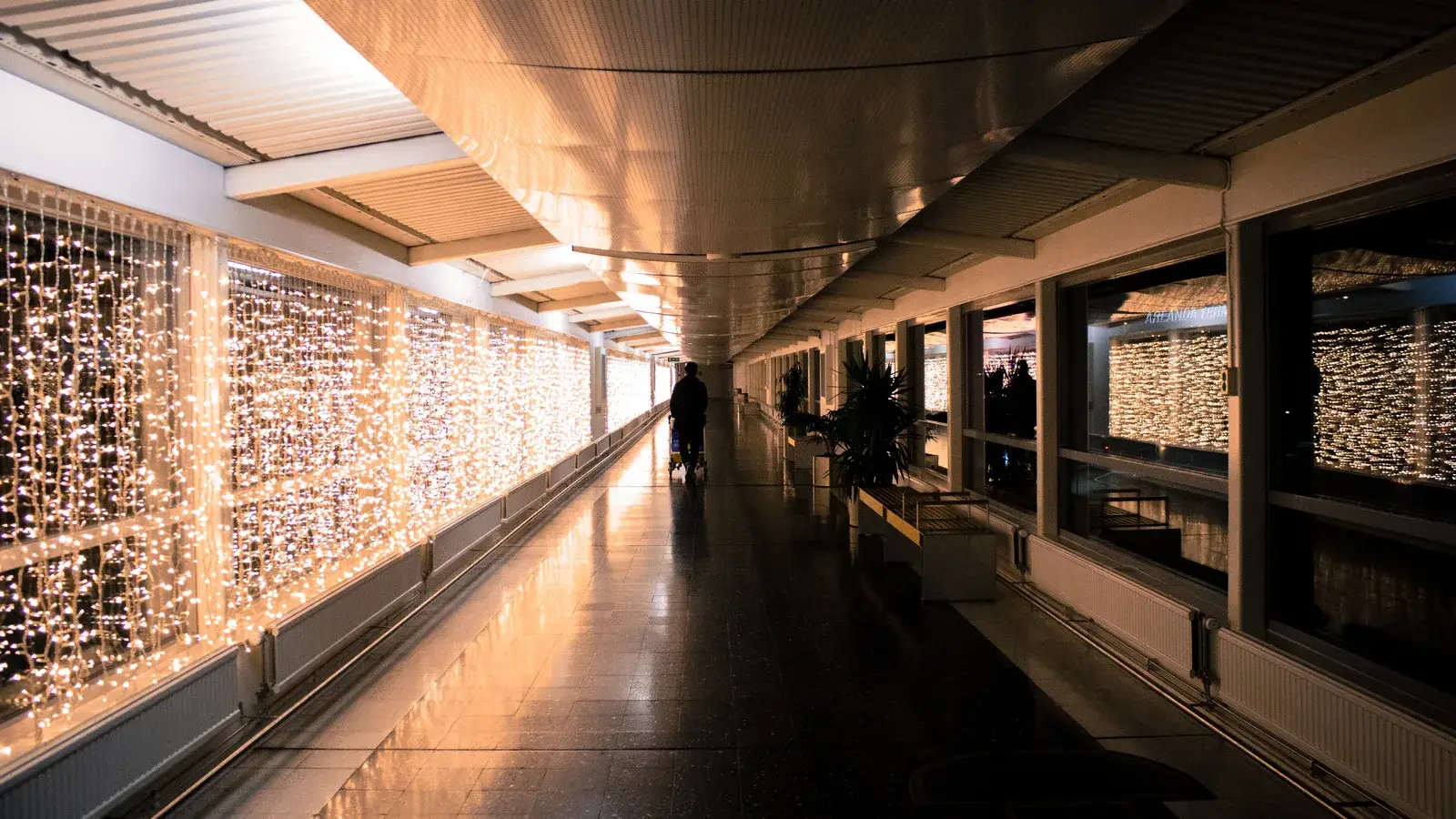 Resenär med bagage i en lång gång på Stockholm Arlanda Airport